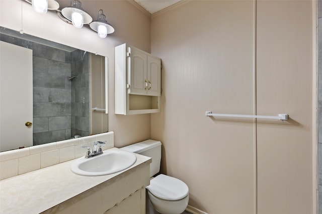 bathroom featuring toilet, vanity, and ornamental molding