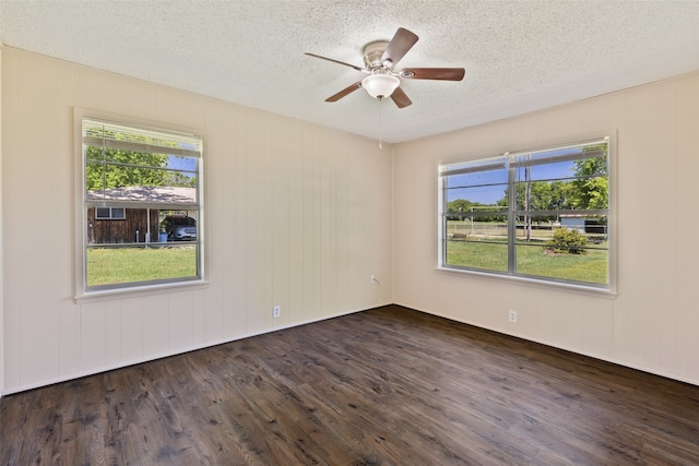 spare room with a textured ceiling, ceiling fan, and dark hardwood / wood-style floors