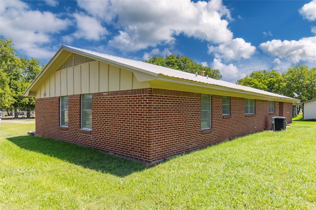 view of home's exterior featuring central air condition unit and a lawn