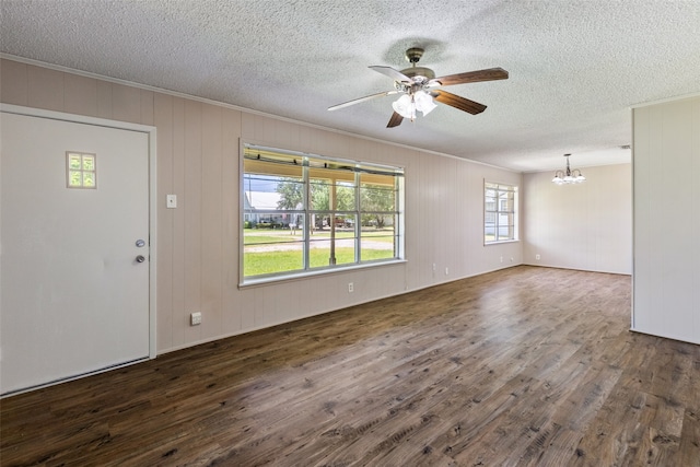 interior space featuring ornamental molding, a textured ceiling, ceiling fan with notable chandelier, and dark hardwood / wood-style floors