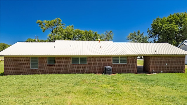 rear view of house with a yard and central AC unit