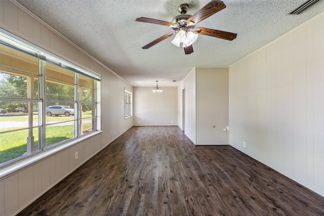 empty room with dark wood-type flooring, ceiling fan with notable chandelier, and a textured ceiling