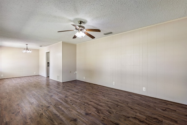 empty room with a textured ceiling, ceiling fan with notable chandelier, crown molding, and dark wood-type flooring