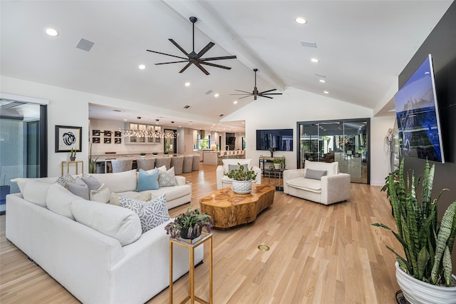 living room featuring ceiling fan, light hardwood / wood-style floors, and vaulted ceiling with beams