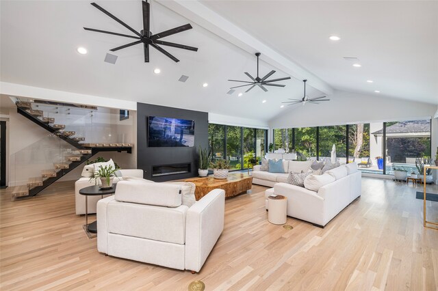 living room featuring light hardwood / wood-style flooring, ceiling fan, and vaulted ceiling with beams