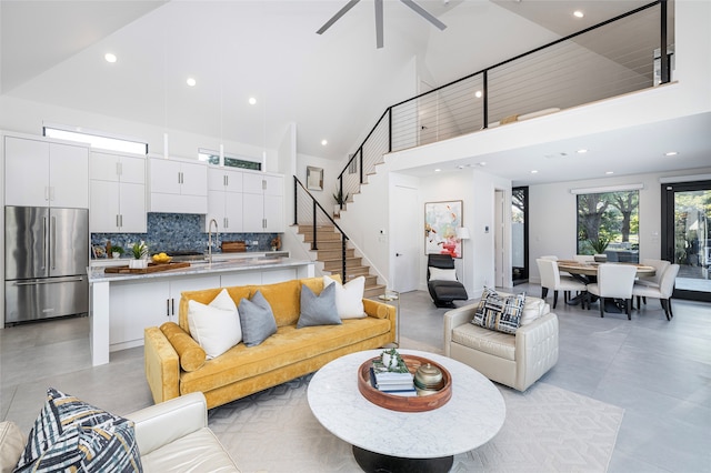 living room with sink, ceiling fan, and a high ceiling