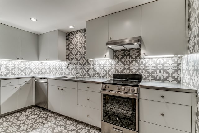 kitchen featuring appliances with stainless steel finishes, gray cabinetry, sink, backsplash, and light tile patterned floors