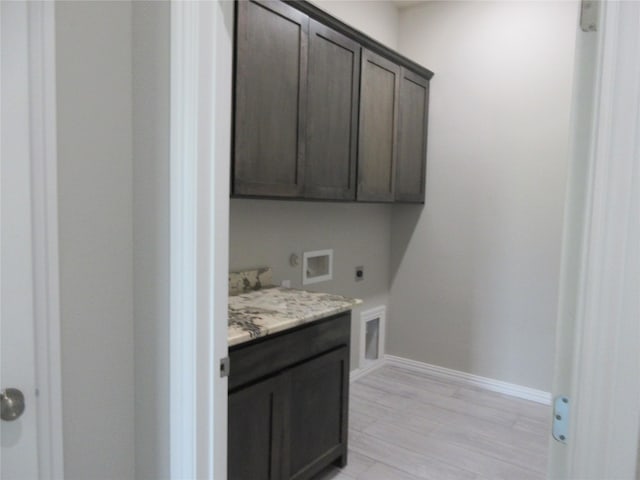 laundry room with cabinets, washer hookup, light wood-type flooring, and hookup for an electric dryer