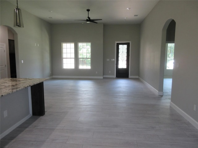 unfurnished living room with ceiling fan and light hardwood / wood-style flooring