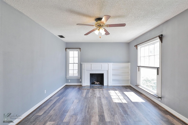 unfurnished living room with hardwood / wood-style floors, a textured ceiling, a fireplace, and ceiling fan