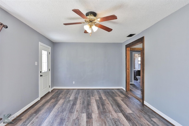 unfurnished room with dark wood-type flooring, ceiling fan, and a textured ceiling