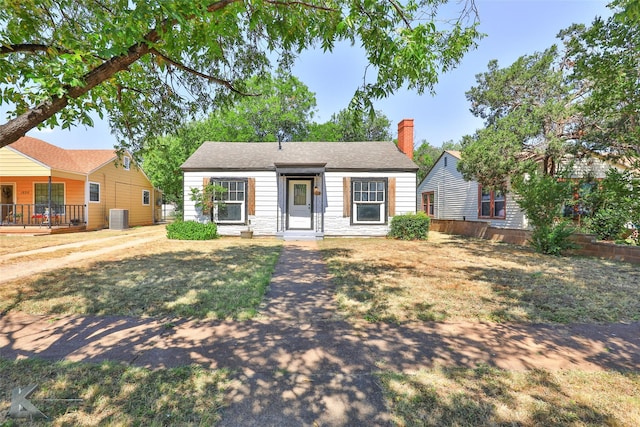 view of front of house featuring cooling unit and a front lawn