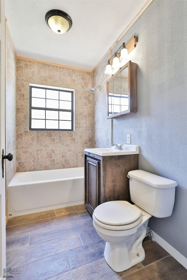 full bathroom featuring tiled shower / bath, vanity, and toilet