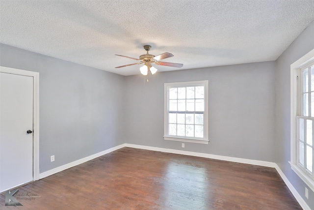 unfurnished room with a textured ceiling, dark wood-type flooring, and ceiling fan