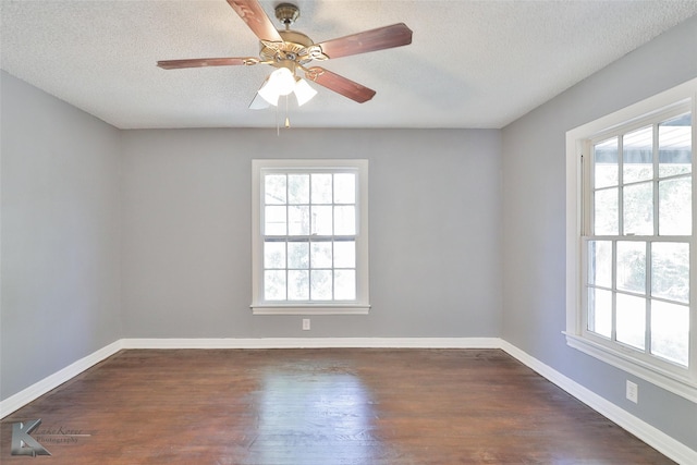 spare room with ceiling fan, dark hardwood / wood-style floors, a textured ceiling, and a wealth of natural light