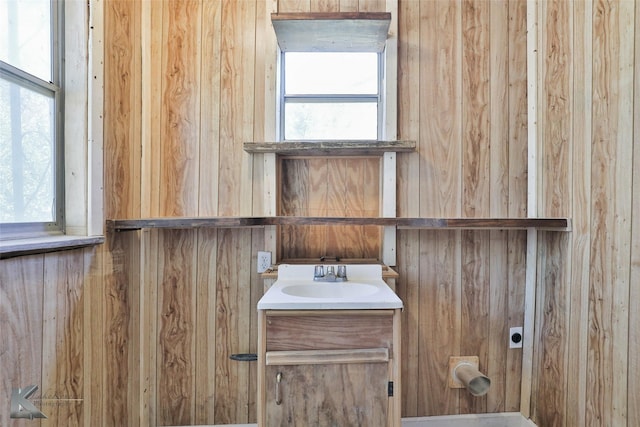 bathroom featuring vanity and wood walls