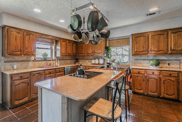 kitchen with sink, dark tile patterned floors, decorative backsplash, and a kitchen island