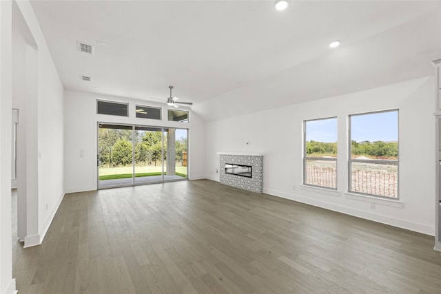 unfurnished living room with visible vents, wood finished floors, a ceiling fan, and a stone fireplace