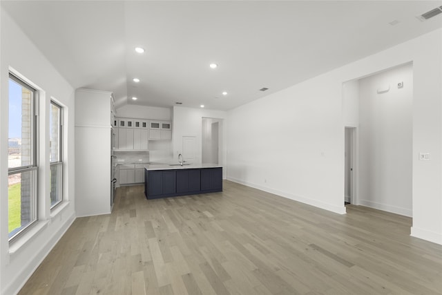 kitchen with plenty of natural light, white cabinets, visible vents, and a sink