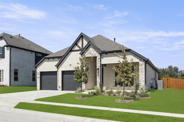 view of front facade with driveway, brick siding, fence, an attached garage, and a front yard