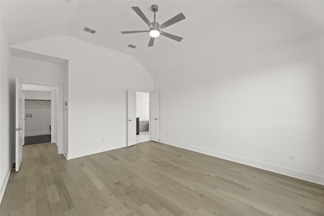 unfurnished bedroom featuring vaulted ceiling, light wood finished floors, baseboards, and visible vents