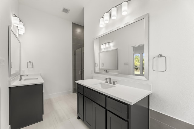 full bath with a shower stall, visible vents, two vanities, and a sink