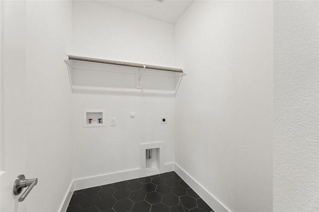 washroom with washer hookup, dark tile patterned flooring, hookup for a gas dryer, hookup for an electric dryer, and laundry area