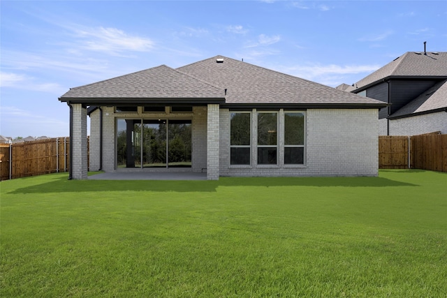 back of property featuring a yard, a patio, brick siding, and a fenced backyard