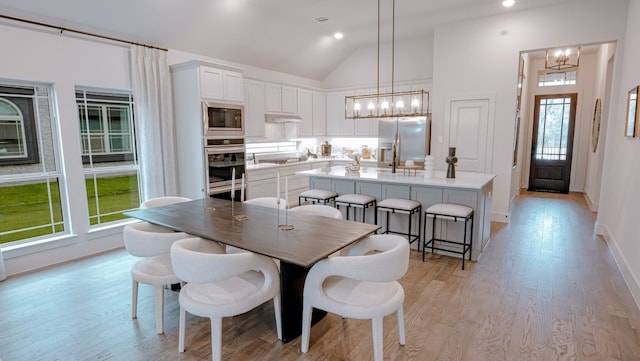 dining space featuring an inviting chandelier, lofted ceiling, and a wealth of natural light