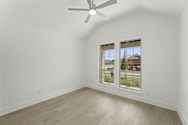 empty room with vaulted ceiling, light wood-style flooring, baseboards, and ceiling fan