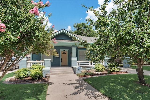 view of front of property with a porch and a front lawn