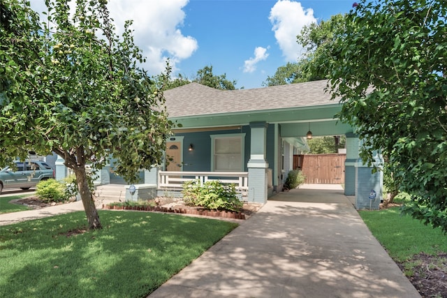 view of front of property with a carport, a porch, and a front lawn