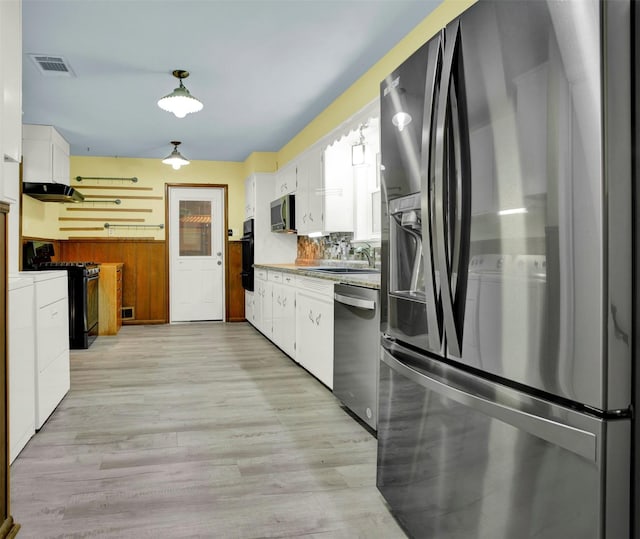 kitchen featuring backsplash, white cabinets, sink, light hardwood / wood-style floors, and stainless steel appliances