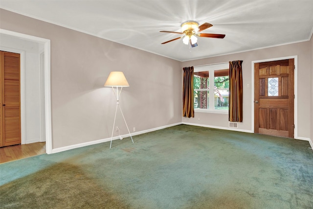 unfurnished living room with ceiling fan, crown molding, and dark carpet