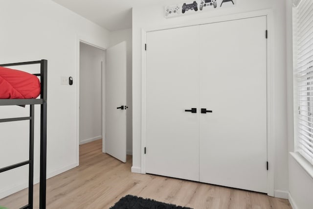 bedroom with a closet and light hardwood / wood-style flooring