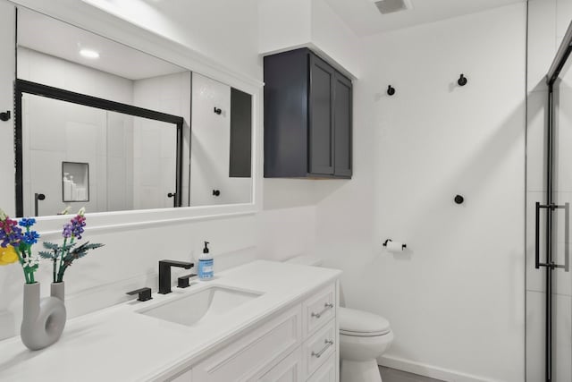 bathroom with toilet, walk in shower, and vanity