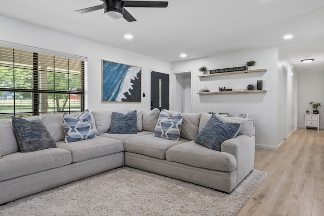 living room featuring ceiling fan and light hardwood / wood-style flooring