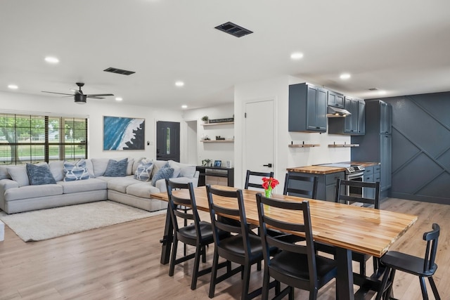 dining space with light wood-type flooring and ceiling fan