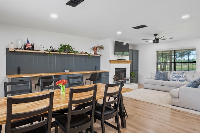 dining room with ceiling fan and light hardwood / wood-style floors