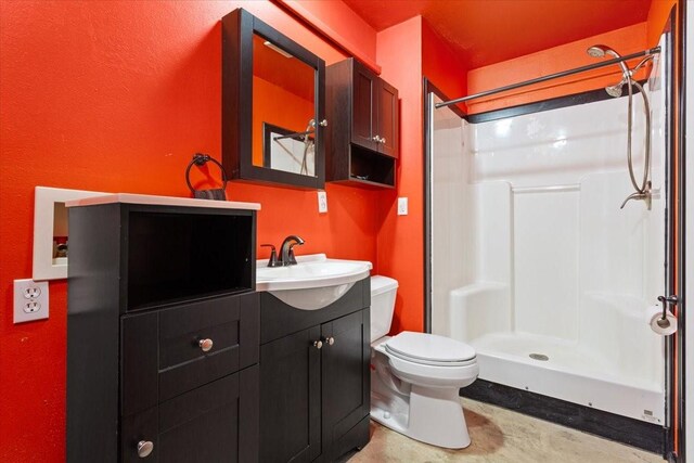 bathroom featuring vanity, walk in shower, concrete flooring, and toilet