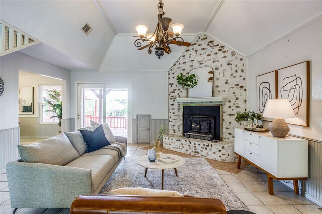 living room with light tile patterned floors, vaulted ceiling, an inviting chandelier, and ornamental molding