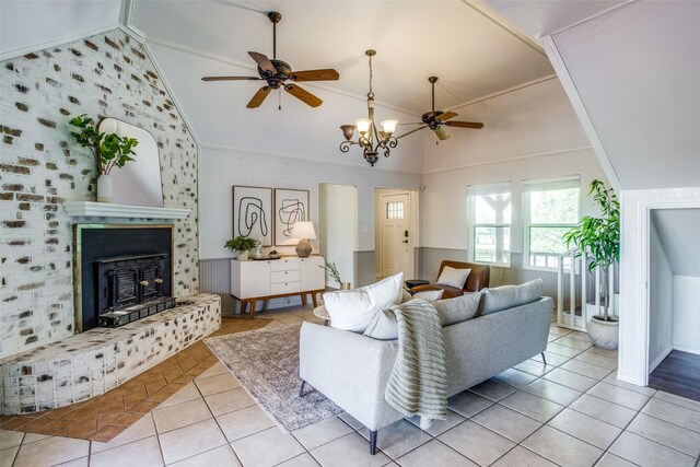 living room with light tile patterned floors, crown molding, ceiling fan with notable chandelier, and high vaulted ceiling