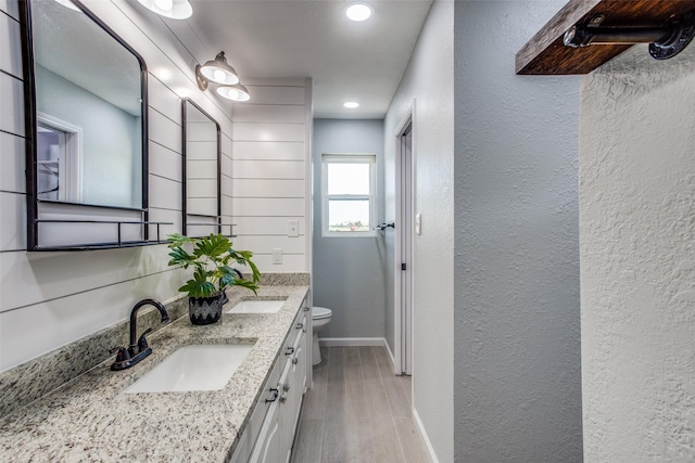 bathroom featuring toilet, hardwood / wood-style floors, and vanity