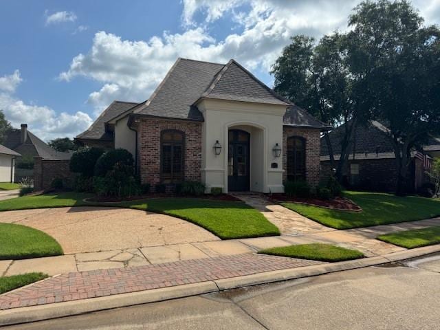 french country home featuring a front lawn