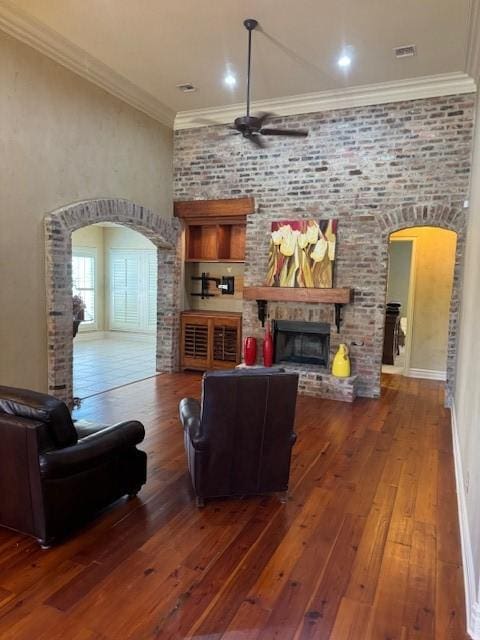 living room with ornamental molding, dark hardwood / wood-style floors, and a fireplace