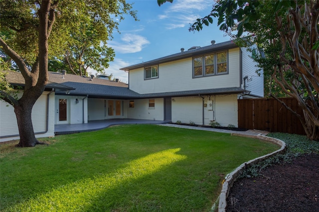 back of house with a lawn and a patio