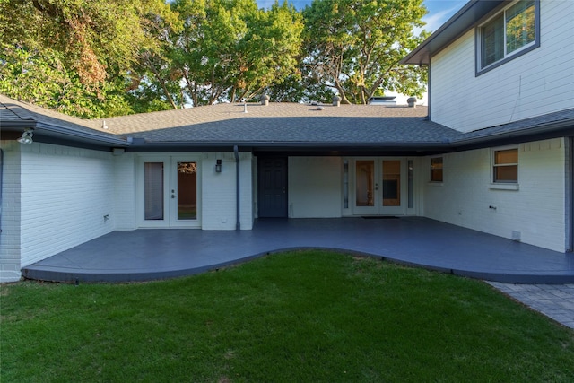 rear view of house with a patio area, french doors, and a lawn