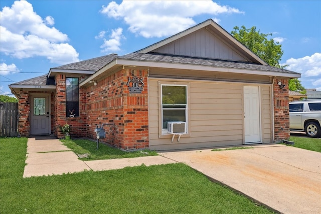 view of front of home featuring cooling unit and a front yard