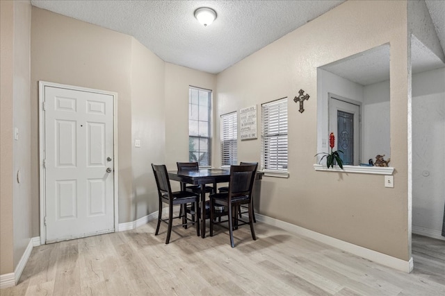 dining room with a textured ceiling and light hardwood / wood-style flooring