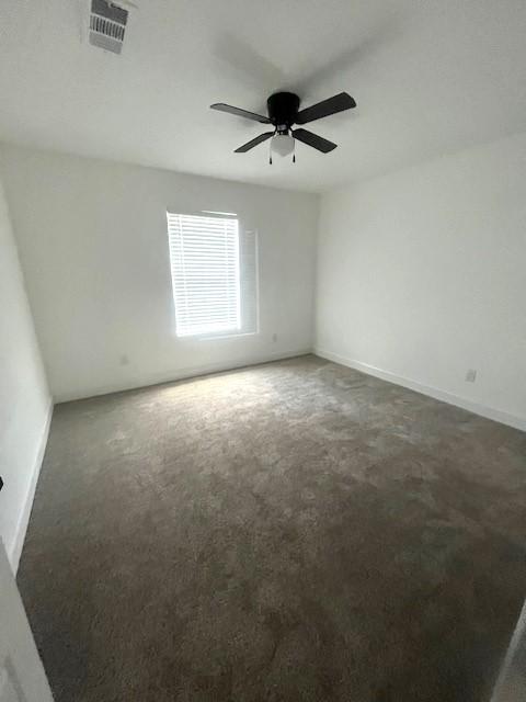 carpeted empty room featuring ceiling fan